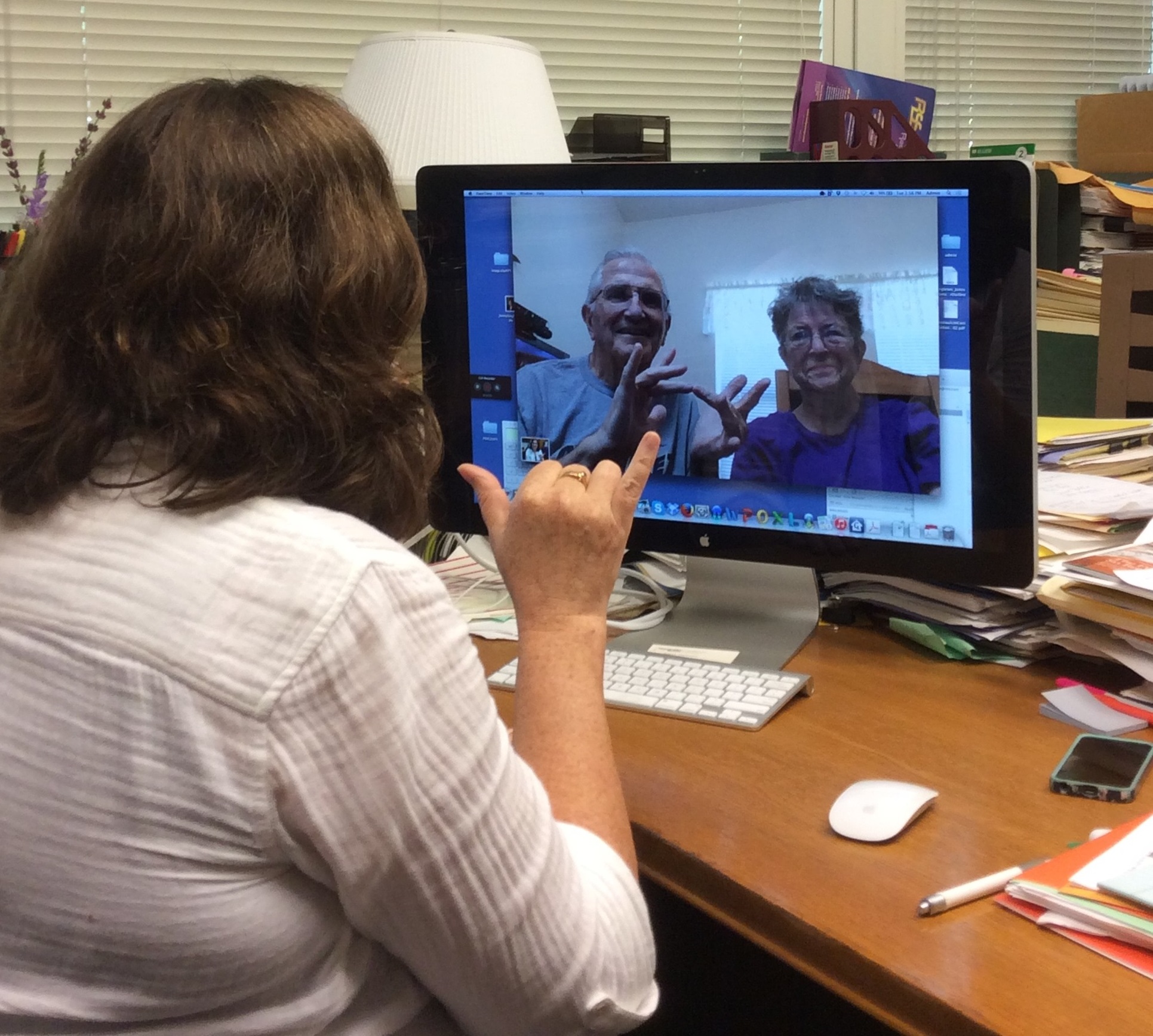 Woman talking to couple using sign language using video conferencing